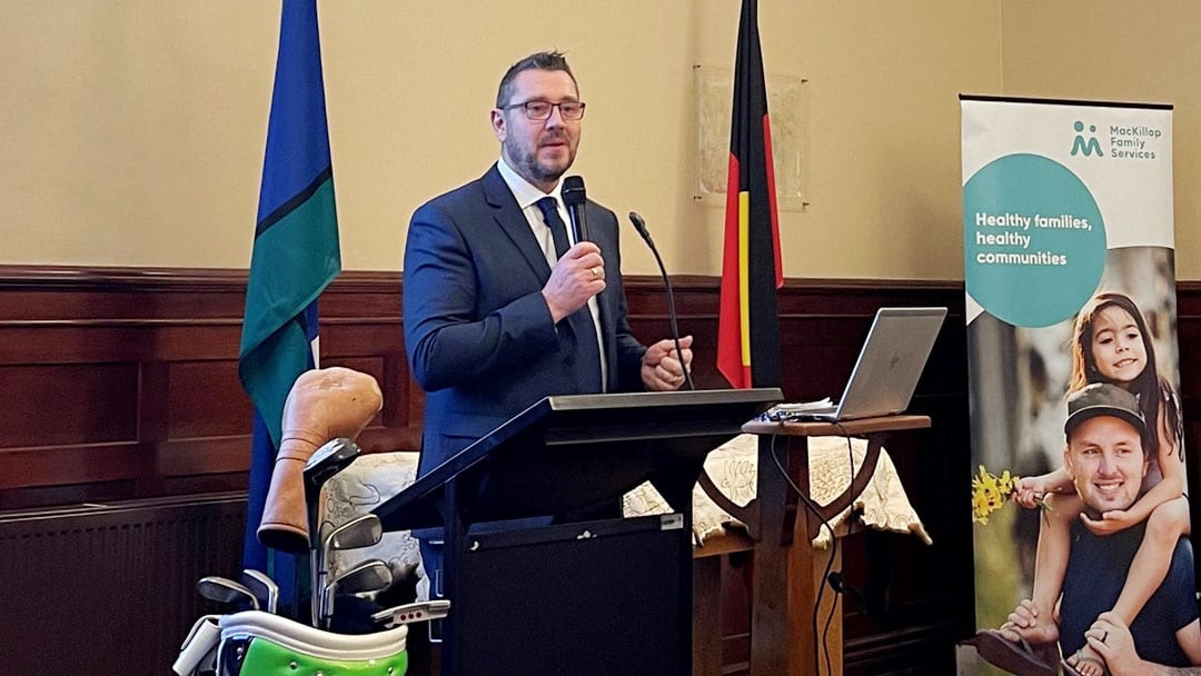 Colin Wilson speaking at a community event lectern